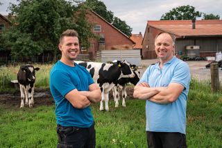 Foto: Jung und Seniorbauer stehen vor Kuhherde
